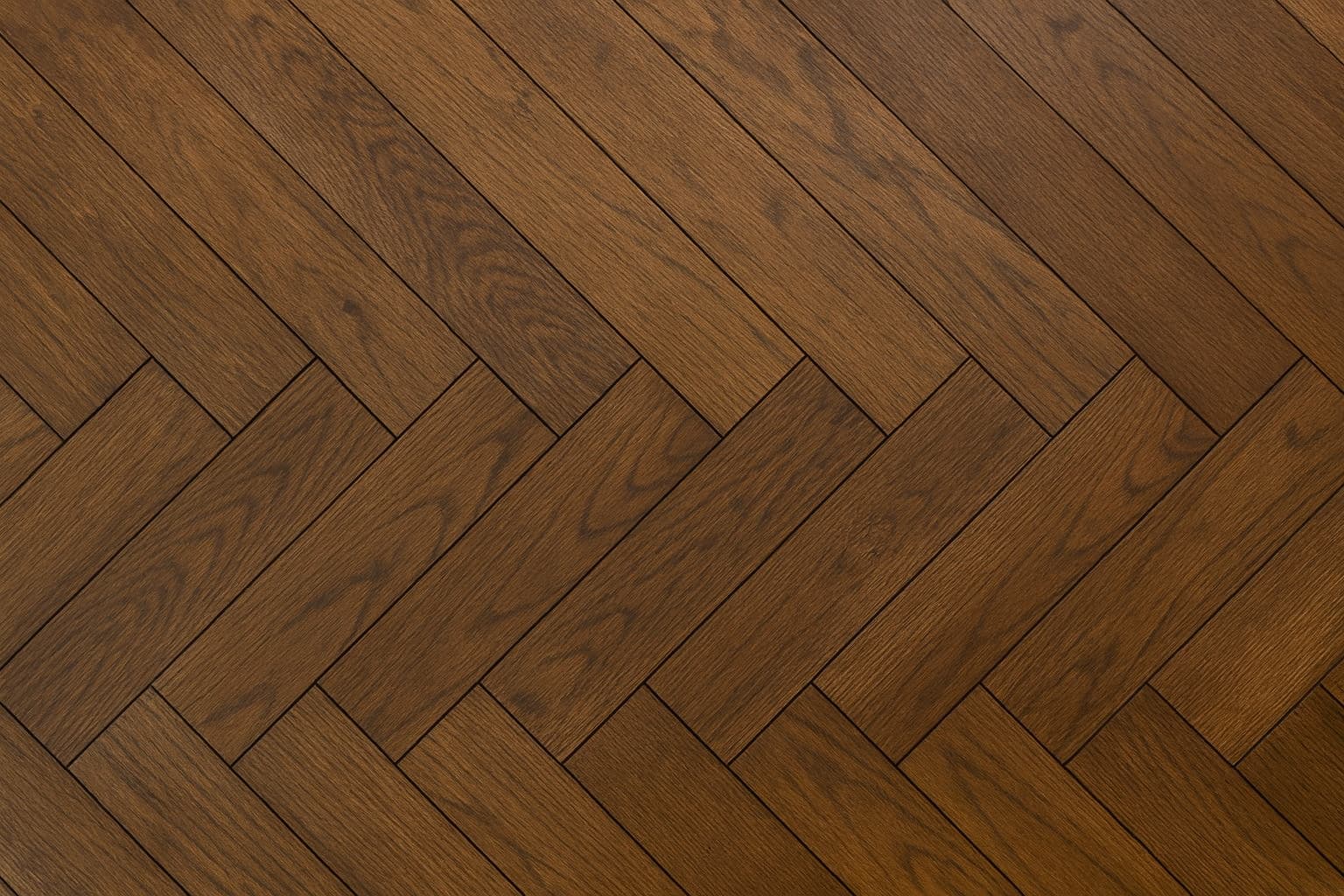 Lämminsävyinen kalanruotokuvioinen parkettilattia läheltä kuvattuna