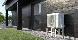 Ilmalämpöpumpun ulkoyksikkö harmaan omakotitalon seinällä